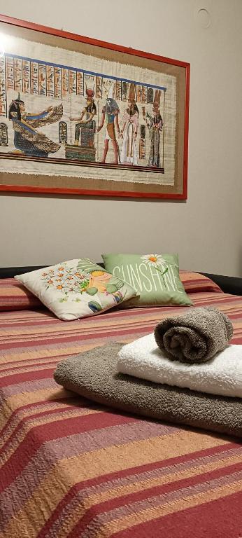 a bed with a blanket and a picture on the wall at La Casetta in Ameno