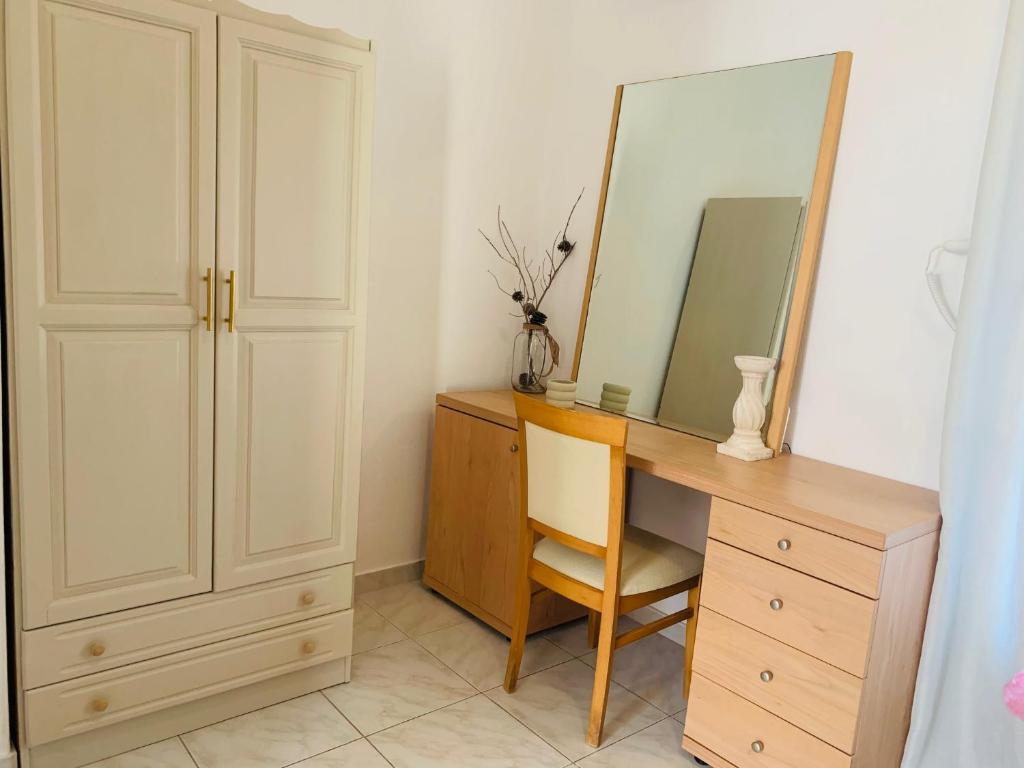 a desk with a mirror and a chair in a room at Skopelos Inn in Stafylos