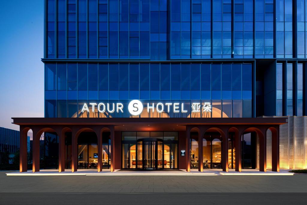 an office building with an entrance to a hotel at Atour Hotel Shanghai Lingang Wanda Plaza in Pengsan