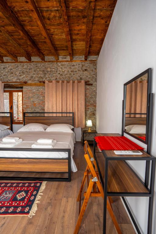 a bedroom with two beds and a desk in it at InTown Guesthouse Shkoder in Shkodër