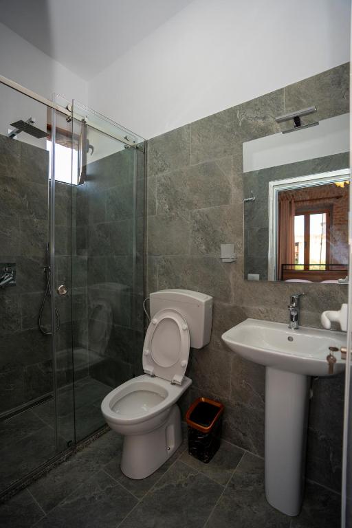 a bathroom with a toilet and a sink and a shower at InTown Guesthouse Shkoder in Shkodër