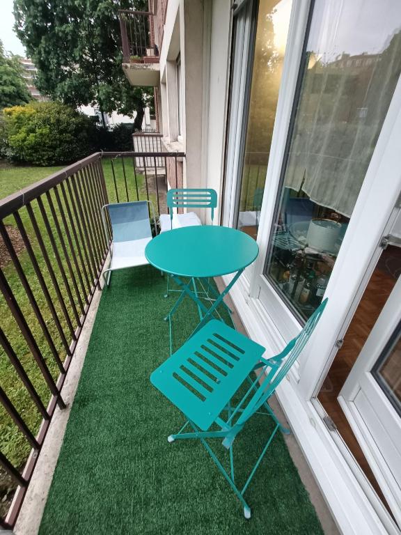 - une table et des chaises sur la terrasse couverte d'une maison dans l'établissement A à Boulogne confort pour sportifs, à Boulogne-Billancourt
