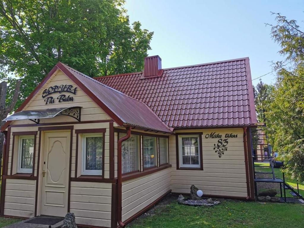 a small house with a red roof at Sodyba pas Babą - namas KLASIKA in Palanga