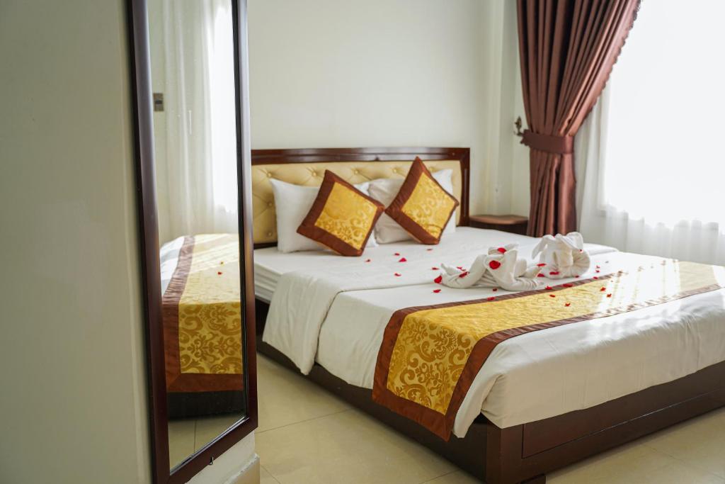 a bedroom with a bed with a mirror at Bu Hotel Thành Phố Huế in Thôn Lại Thê