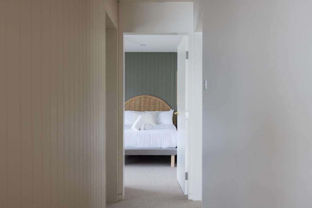 a bedroom with a bed with white sheets at 6 Shoal Edge in Shoal Bay