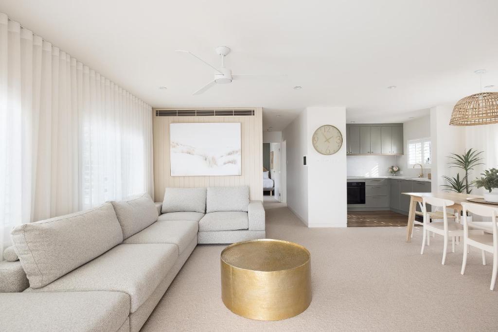 a living room with a couch and a gold table at 6 Shoal Edge in Shoal Bay