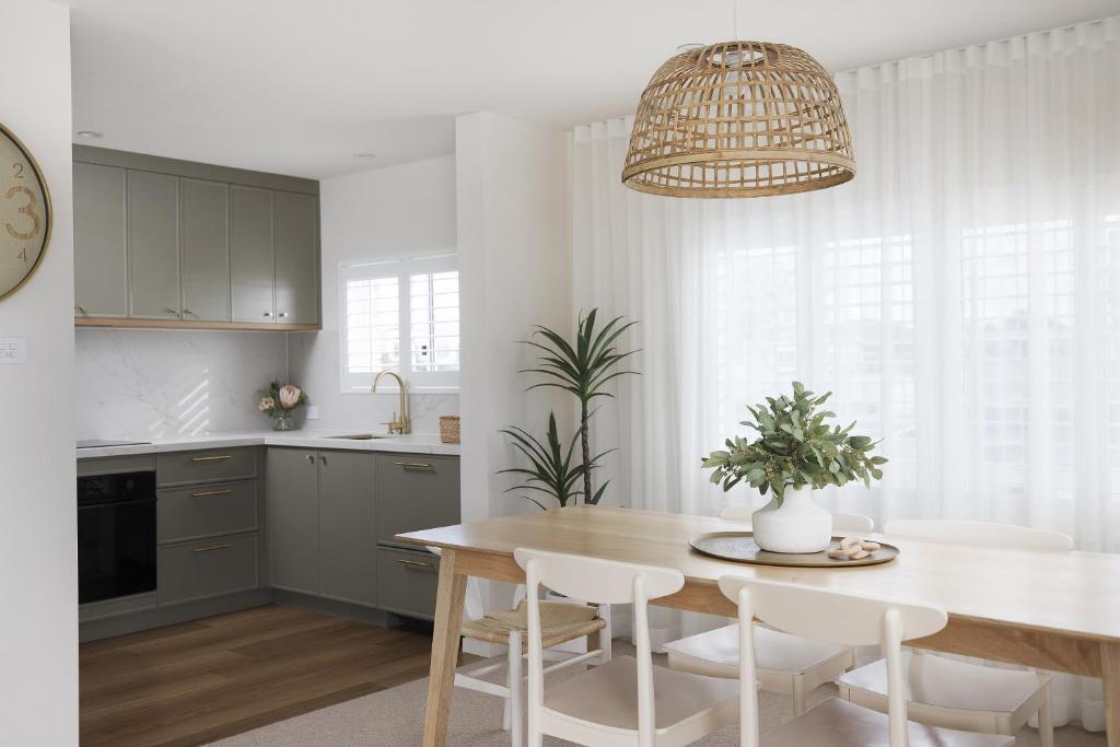 a kitchen and dining room with a table and chairs at 6 Shoal Edge in Shoal Bay