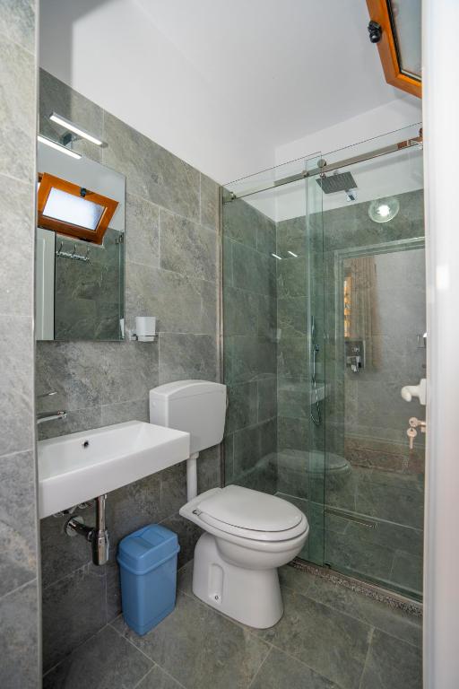a bathroom with a toilet and a sink and a shower at InTown Guesthouse Shkoder in Shkodër