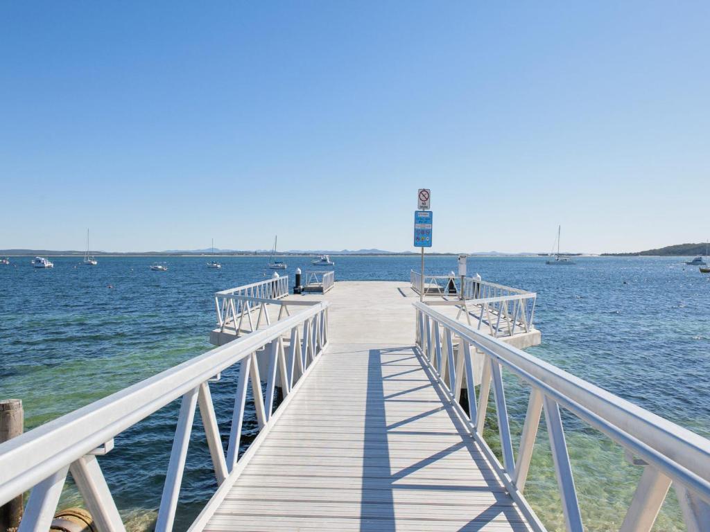 a wooden pier in the middle of the water at 6 Shoal Edge in Shoal Bay