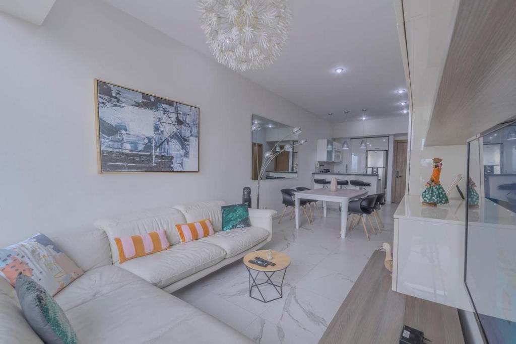 sala de estar con sofá blanco y comedor en Apt with Reforma View Pool and Jacuzzi, en Ciudad de México