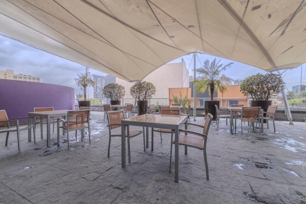 un grupo de mesas y sillas bajo una tienda en Apt with Reforma View Pool and Jacuzzi, en Ciudad de México
