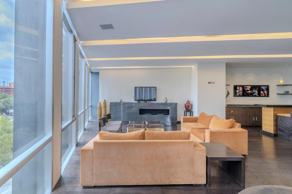 sala de estar con sofás y piano en Apt with Reforma View Pool and Jacuzzi, en Ciudad de México