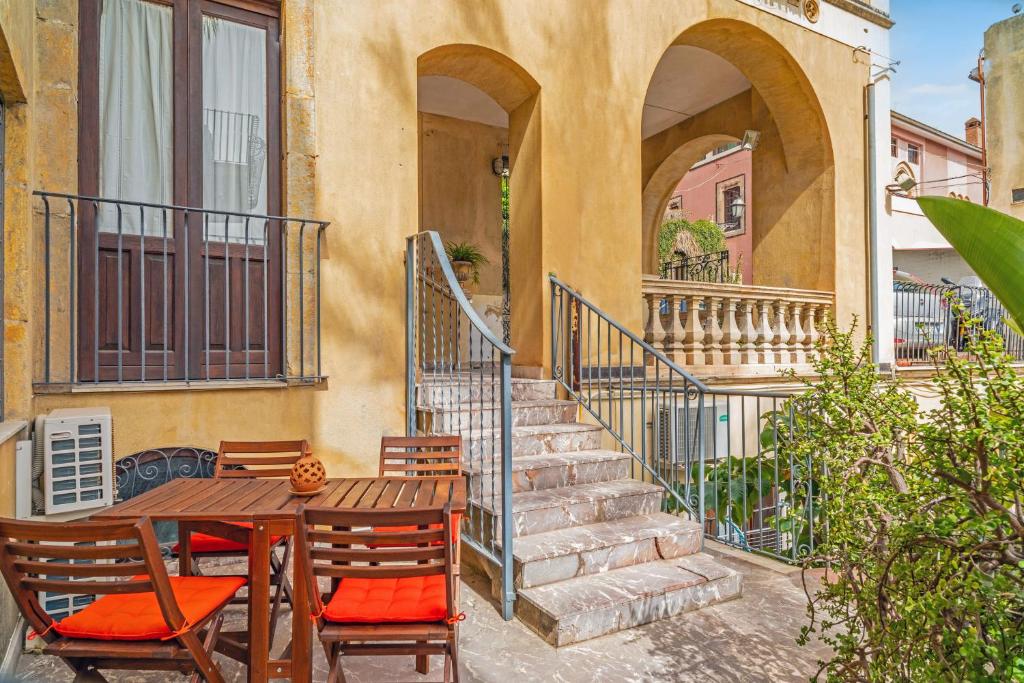 a table and chairs outside of a building with stairs at Casa Fabrizio in Taormina