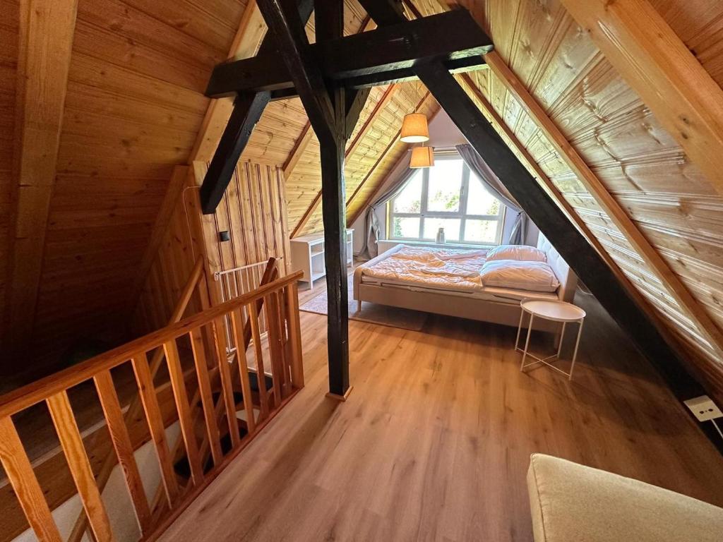 een zolderkamer met een bed en een raam bij Altes Forsthaus Fischbach in Sankt Andreasberg