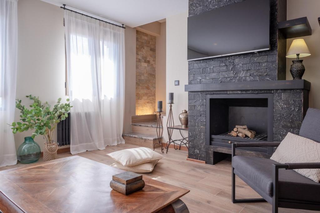 un soggiorno con camino e TV di Espectacular Casa de lujo con chimenea, barbacoa, jacuzzi y vistas panorámicas a toda Granada ad Alfacar