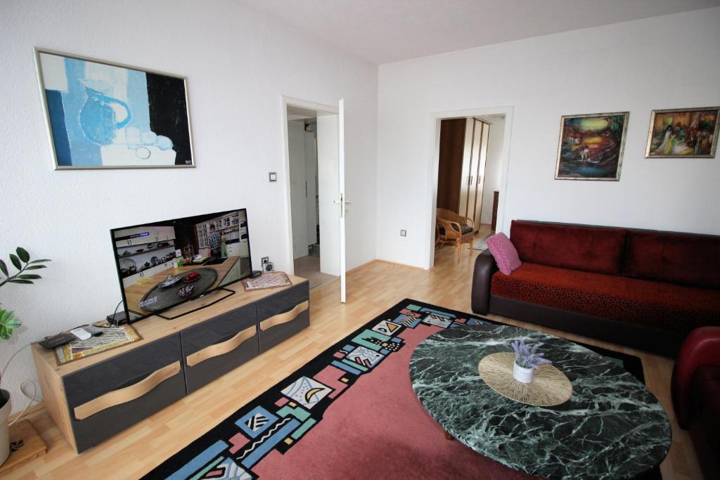 ein Wohnzimmer mit einem roten Sofa und einem Fernseher in der Unterkunft Apartman Mak in Bihać