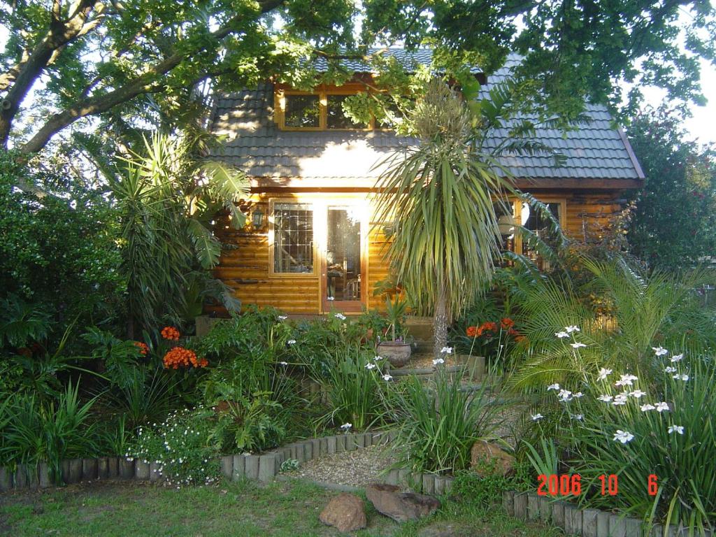 a log cabin with a garden in front of it at Log Villa in Cape Town