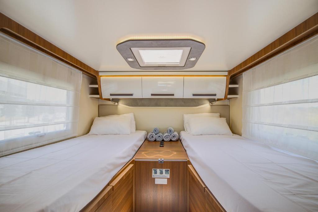 a small bedroom with two beds in a caravan at Autocaravana Baron 573 in Cerdanyola del Valles