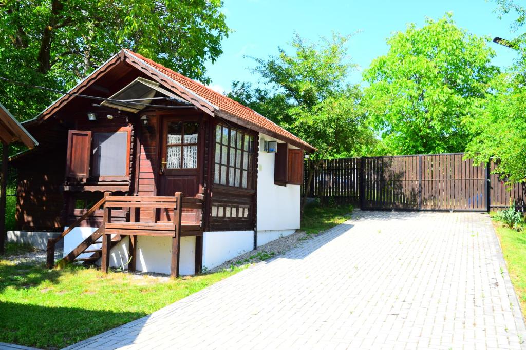 a small house with a bench next to a fence at G&G Vacation Home in Cîlnic