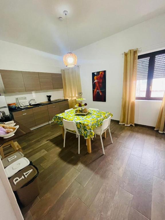 a living room with a table and chairs and a kitchen at Casa Politeama Spacious Central Flat by Oplonti Station for Pompeii, Sorrento and Naples in Torre Annunziata