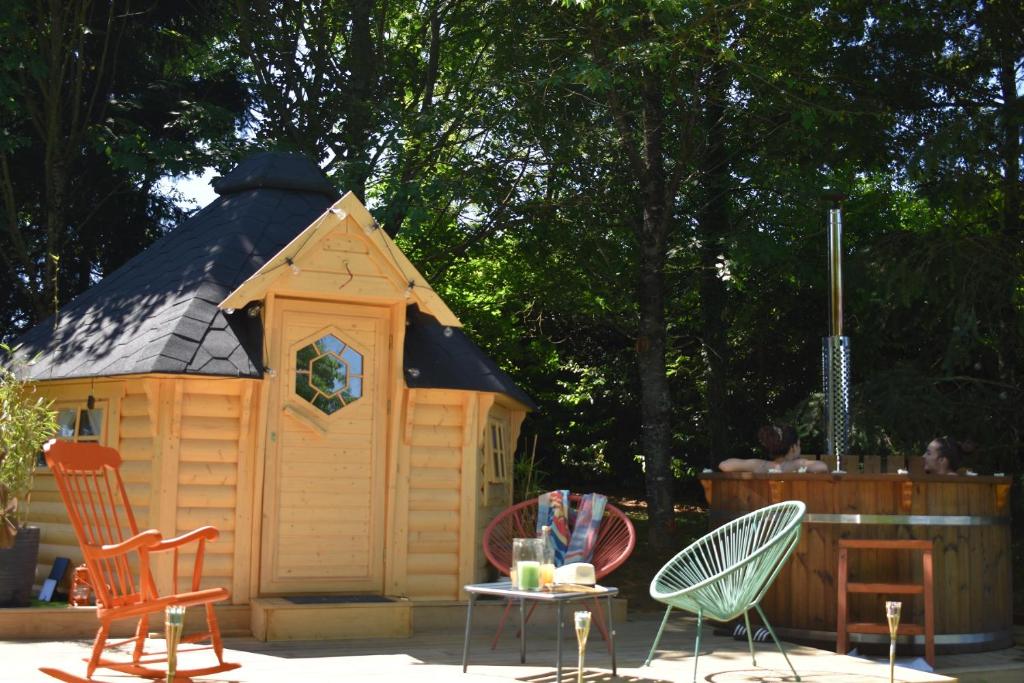 drewniany domek zabaw ze stołem i krzesłami w obiekcie Cabane dans un jardin arboré w mieście LʼAbsie