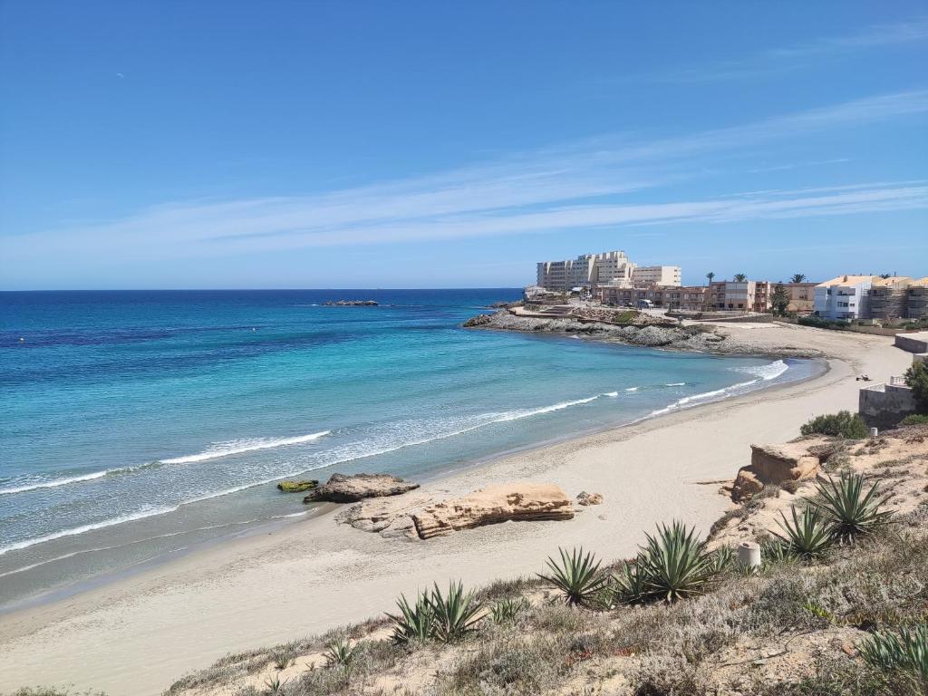 vista su una spiaggia con l'oceano e gli edifici di Retiro MonteMar a La Manga del Mar Menor