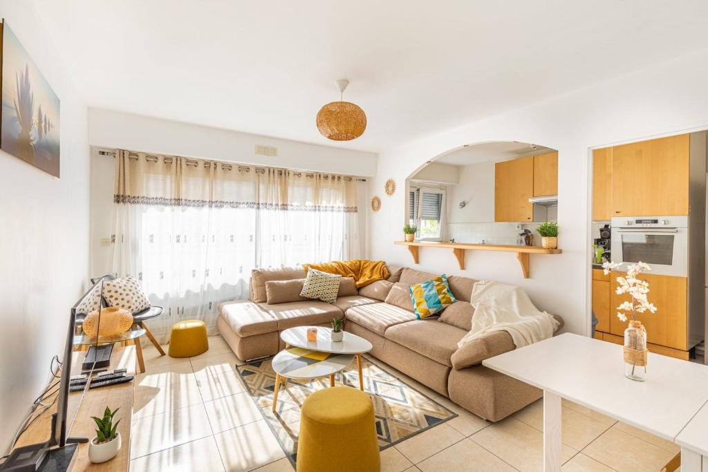 una sala de estar con un sofá y una mesa en GuestReady - Sunny Side Up with Balcony, en Courbevoie