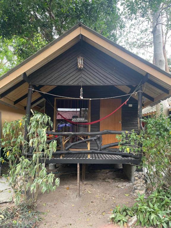 ein kleines Haus mit schwarzem Dach und einer Bank in der Unterkunft Sairee View Resort in Ko Tao