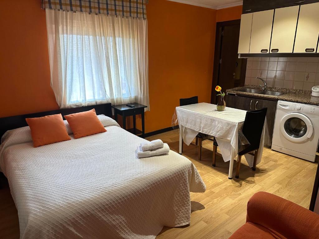 ein Schlafzimmer mit einem Bett und einem Tisch mit einer Waschmaschine in der Unterkunft Casa Blanco Conde in Laza