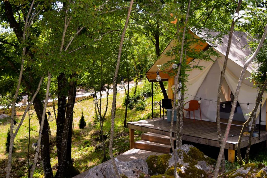 una tenda nel bosco con portico in legno di Oblun Eco Resort - New Glamping Tents near Lake Skadar a Podgorica