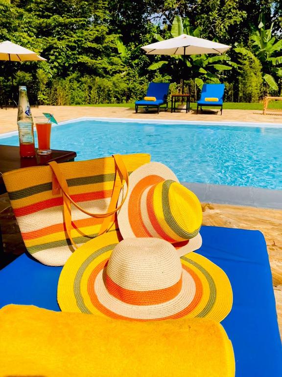 a table with a hat and chairs next to a pool at Kerama Silent Lodge in Arusha