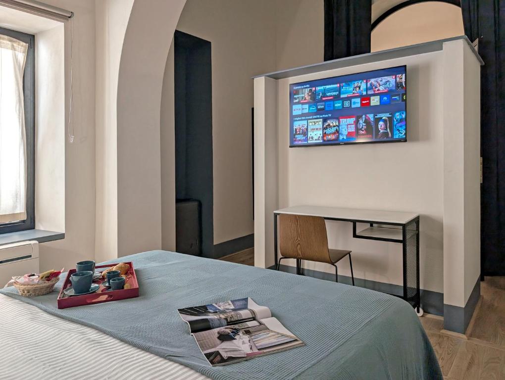 sypialnia z łóżkiem z telewizorem na ścianie w obiekcie La Corte Dei Panni w Rzymie