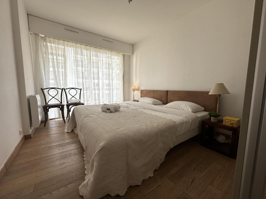 une chambre avec un grand lit et une fenêtre dans l'établissement Charmant 2P Cannes PEL1900, à Cannes