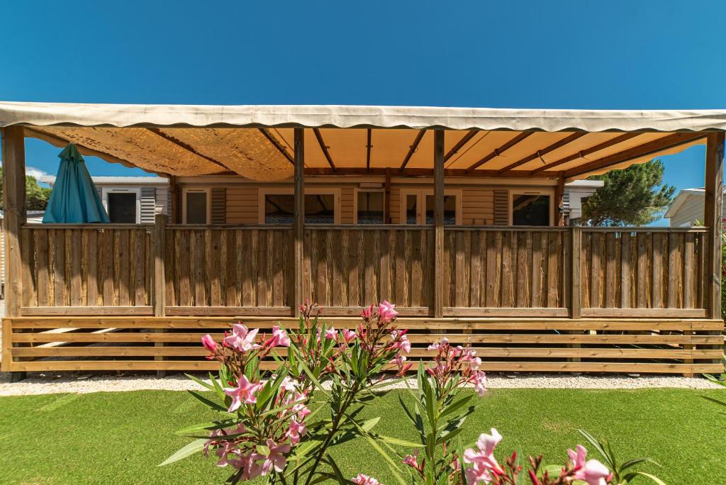 une clôture d'intimité en bois avec une pergola dans l'établissement Mobilhome Mar Estang, à Canet