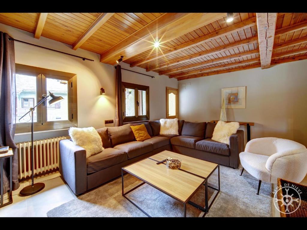 a living room with a couch and a table at CASA BARLONGUETA de Alma de Nieve in Arties