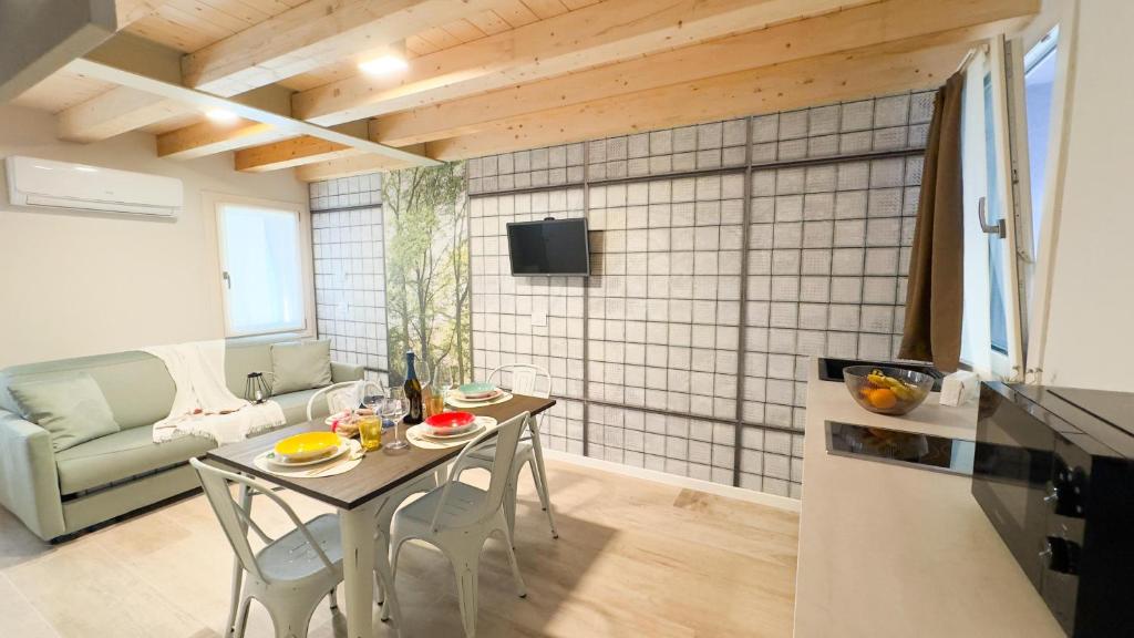 Una cocina y una sala de estar con mesa y sillas. en Graceful Apartments Paradise by Ca-Sa Check, en Chioggia