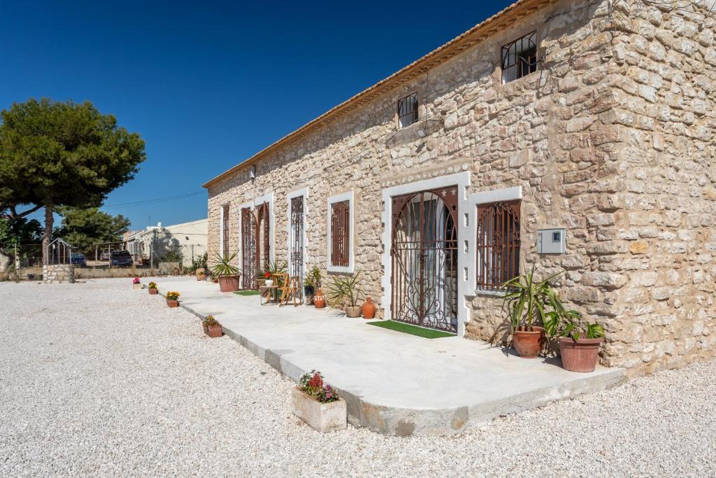 a stone building with potted plants in front of it at Las Casitas Del Mar in Alicante