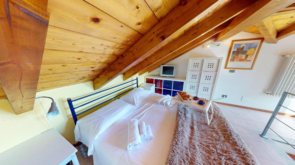 sypialnia z łóżkiem i drewnianym sufitem w obiekcie Domus Minervae - BGL w Manerba del Garda