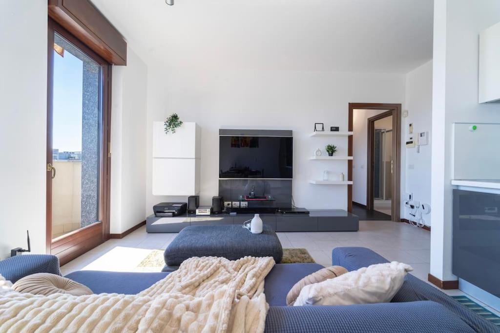 a living room with a blue couch and a tv at Certosa House - Milano in Milan