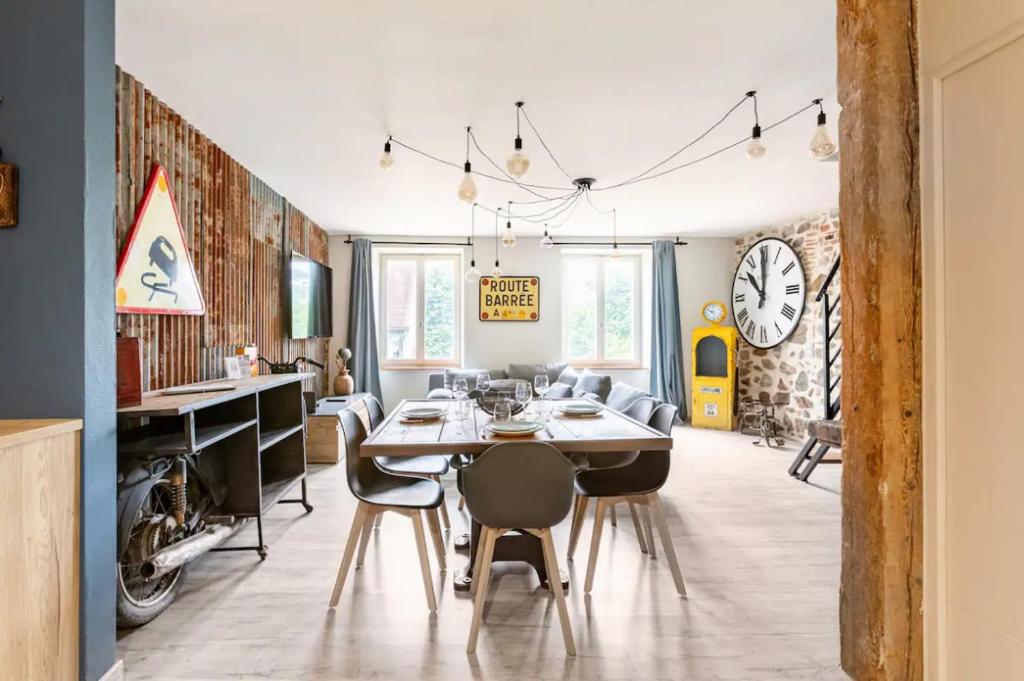 a dining room and living room with a table and chairs at Le Rétro à Kaysersberg in Kaysersberg
