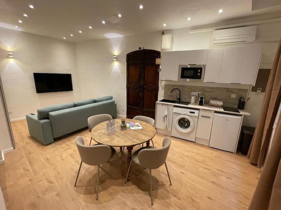 un salon avec une table et un canapé et une cuisine dans l'établissement T2 Cosy - Place des Cardeurs, à Aix-en-Provence