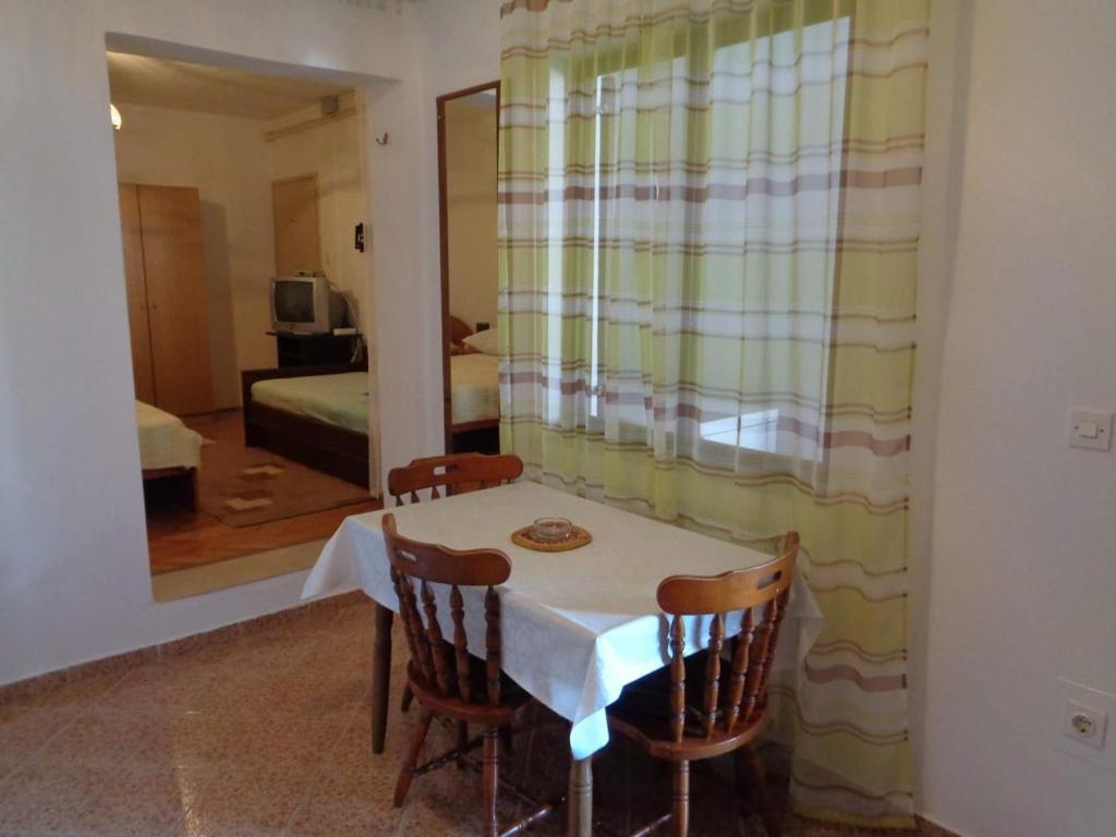 a table and chairs in a room with a bedroom at Apartment Ivan in Sukošan