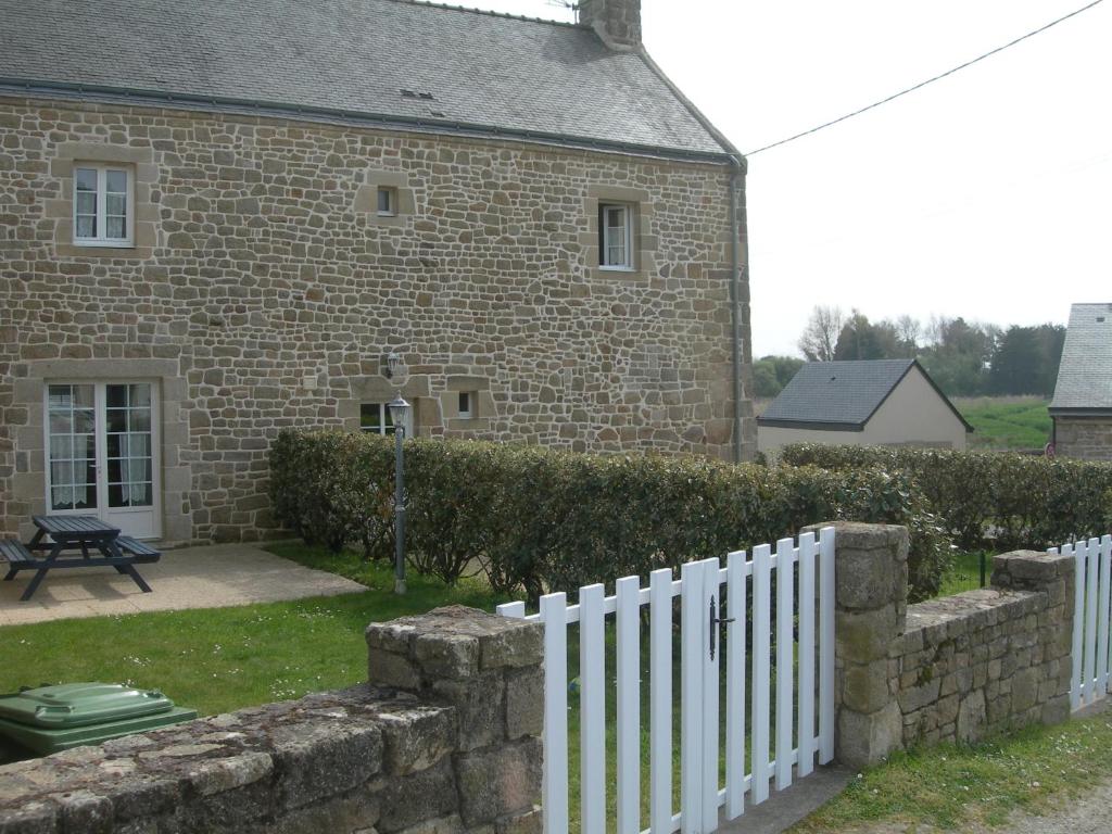 een wit hek voor een bakstenen gebouw bij Gites Erdeven Bretagne Sud in Erdeven