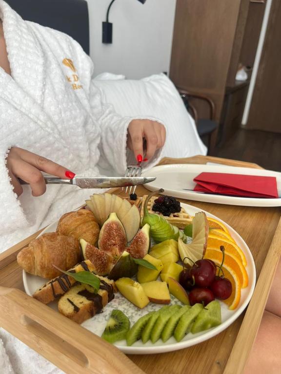 a person laying in a hospital bed with a plate of food at Black Diamond Hotel Dhermi in Dhërmi