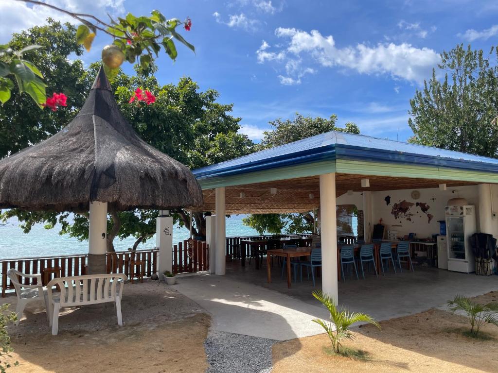 un ristorante con un tetto blu, un tavolo e delle sedie di The Shuim Dive Resort Moalboal a Moalboal