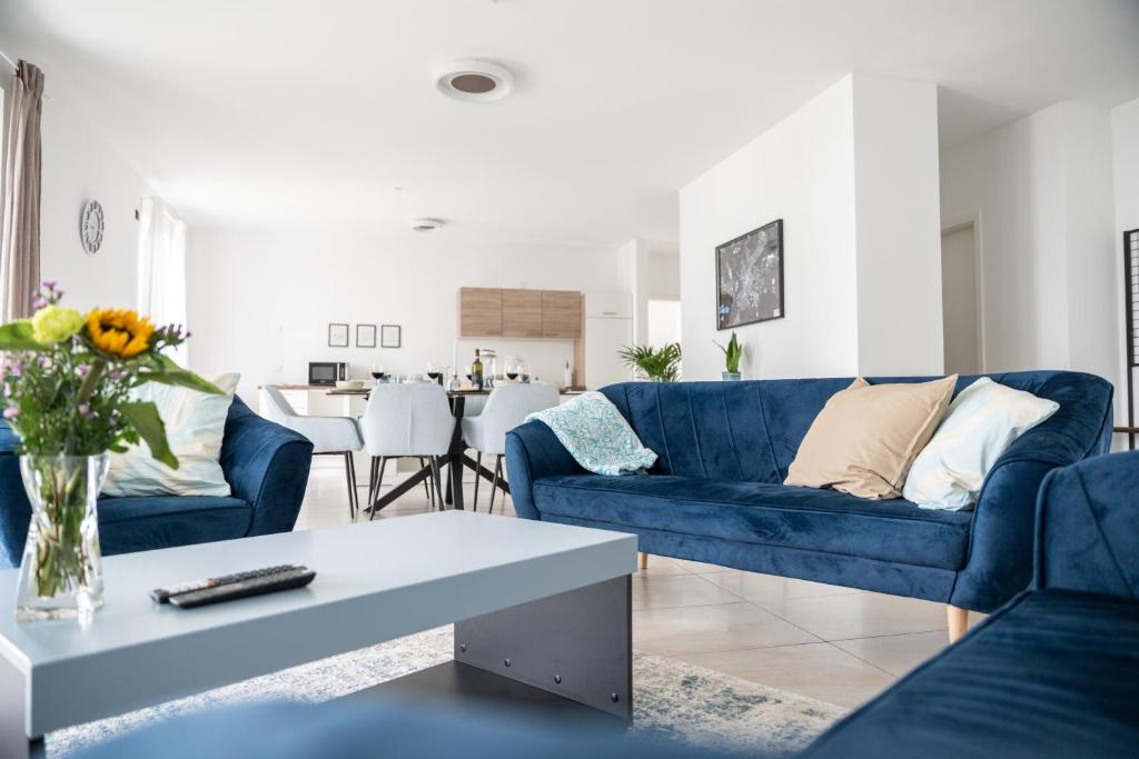 a living room with a blue couch and a table at Zentral - für 6 - 2x frei parken - Terrasse in Gießen