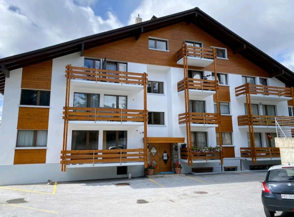 a apartment building with wooden balconies and a parking lot at Charmant appartement avec balcon et parking privé in Lens