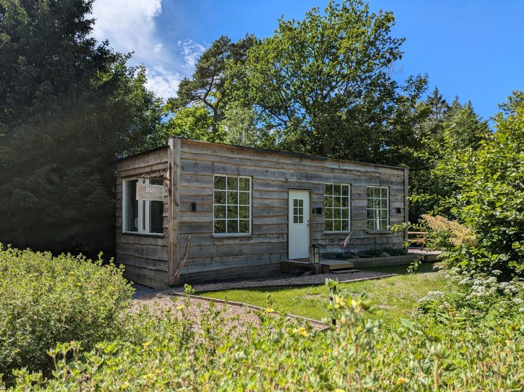 une petite cabane en bois dans une cour arborée dans l'établissement BB Grindhuset, à Larvik
