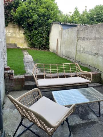 2 chaises et un banc assis sur une terrasse dans l'établissement La jolie citadine, à Tourcoing