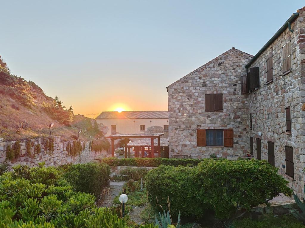 a building with the sunset in the background at House by the sea in Gonnesa